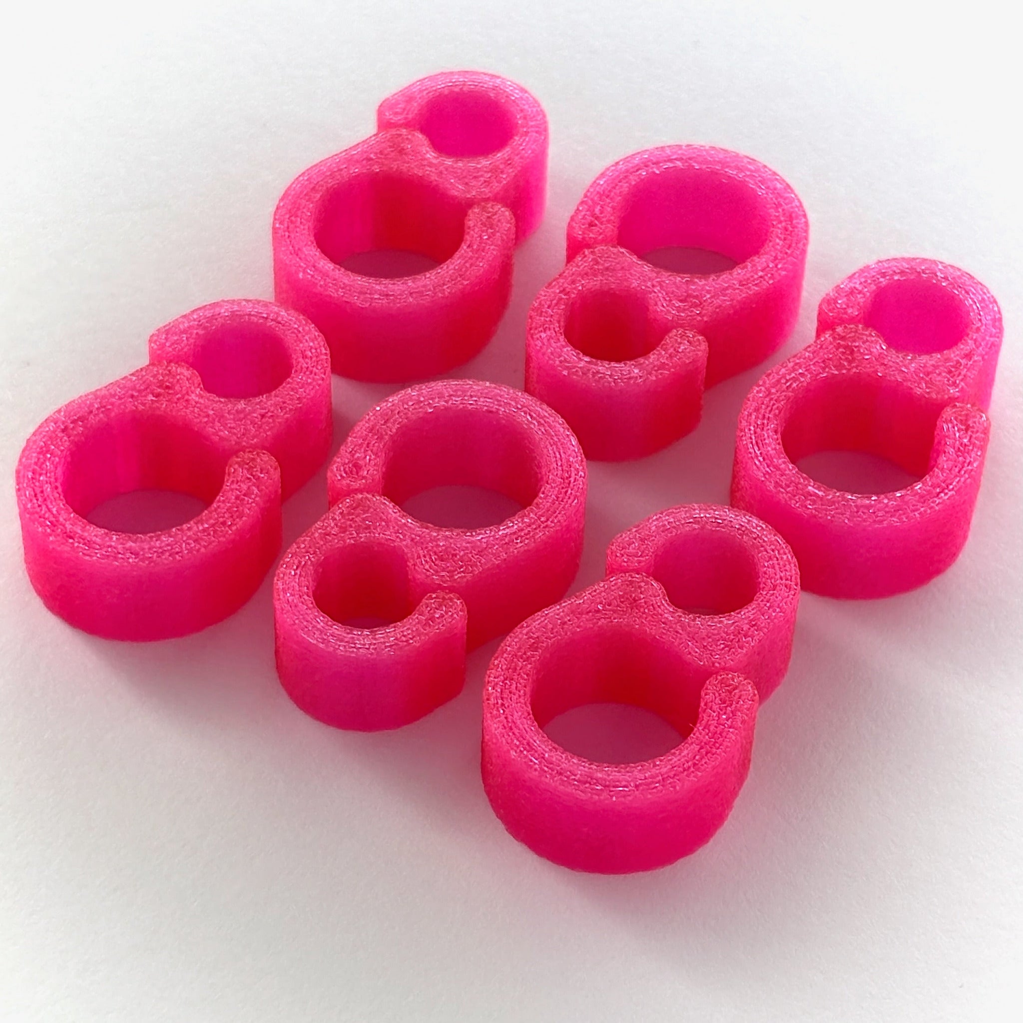 six limited edition pink cineAKS cable tidies on a white background