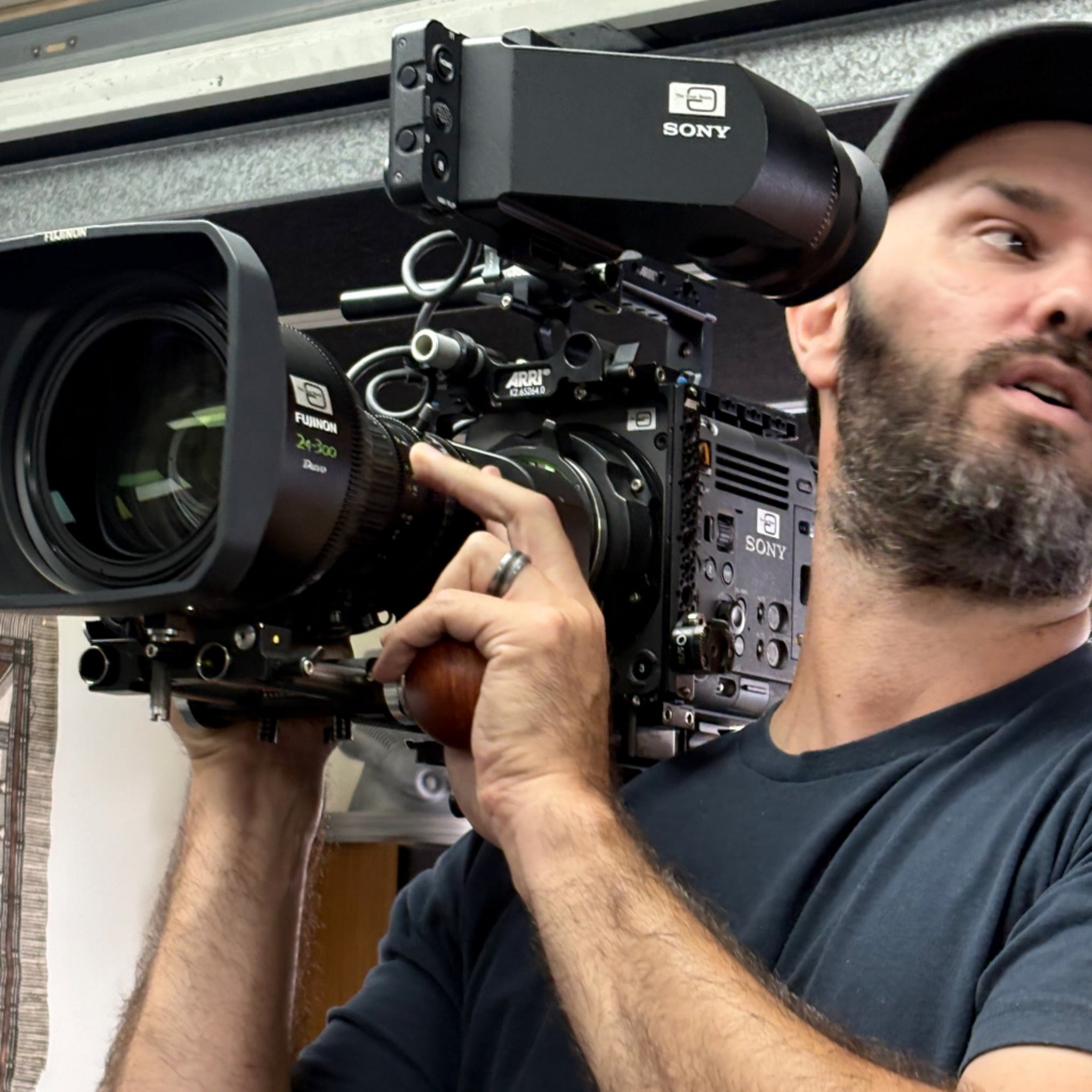 Camera operator using a wooden camera handle on a Sony Burano with Fujinon 24-300mm lens
