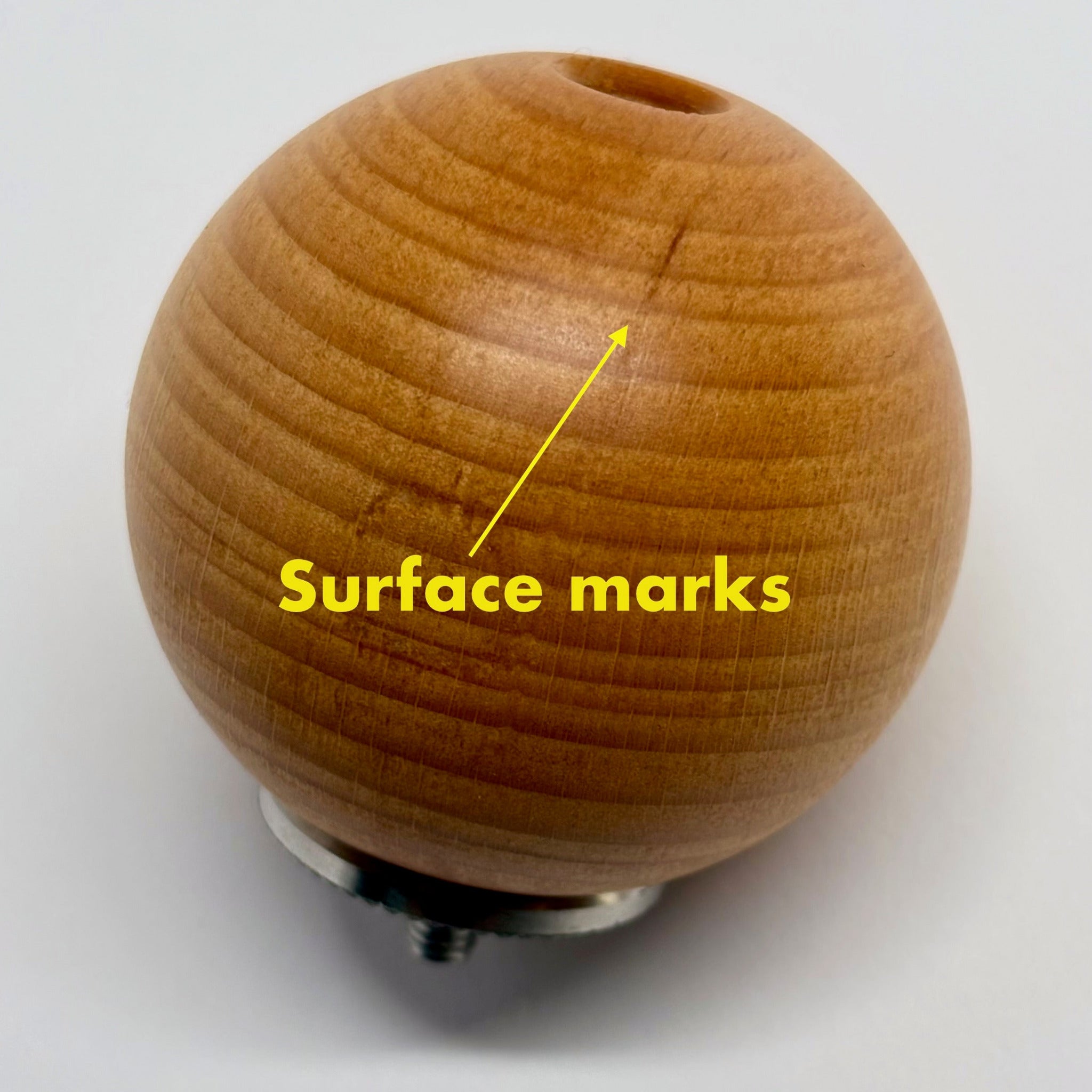 Wooden ball with surface marks highlighted on a white background