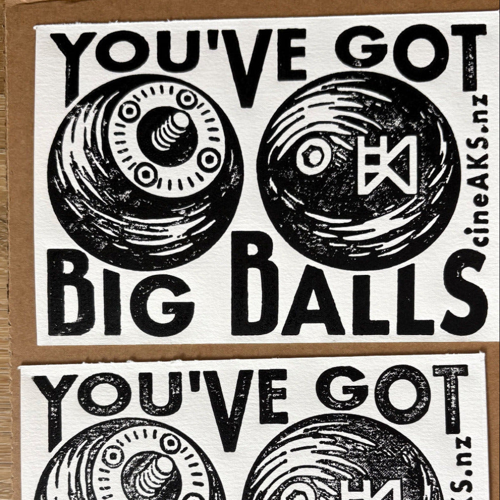 Card with text 'YOU'VE GOT BIG BALLS' and symbols, featuring a brand logo at the bottom.