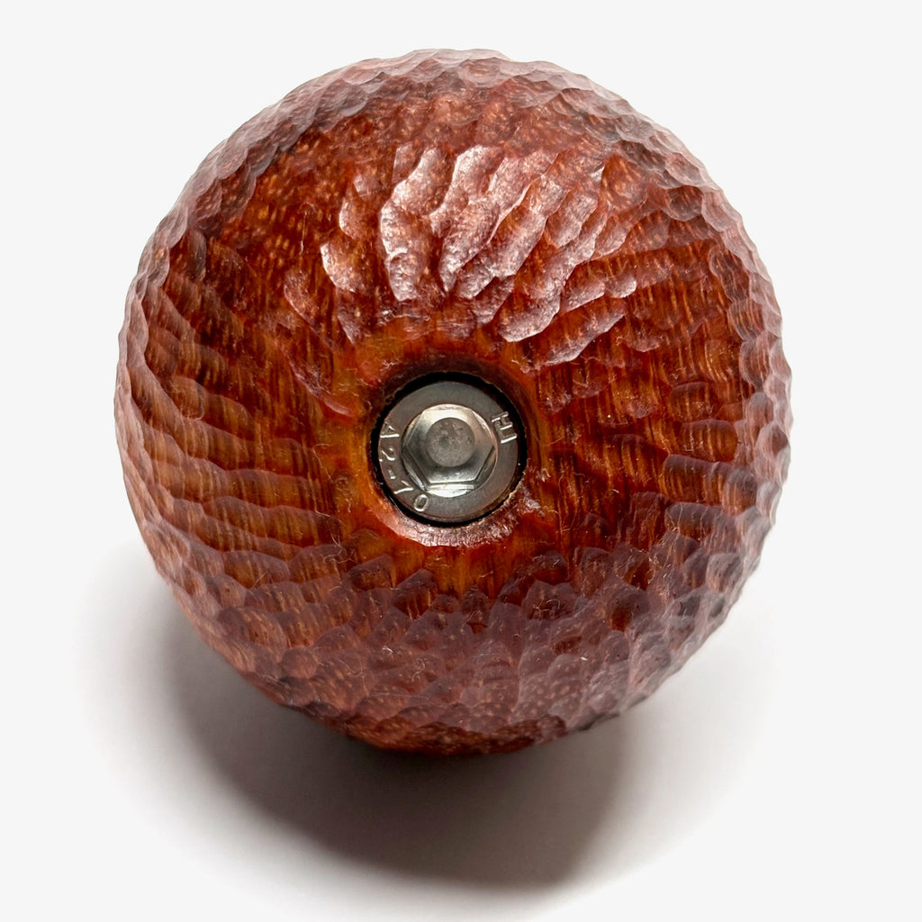 Wooden camera handle from hand carved padauk with rosette center on a white background