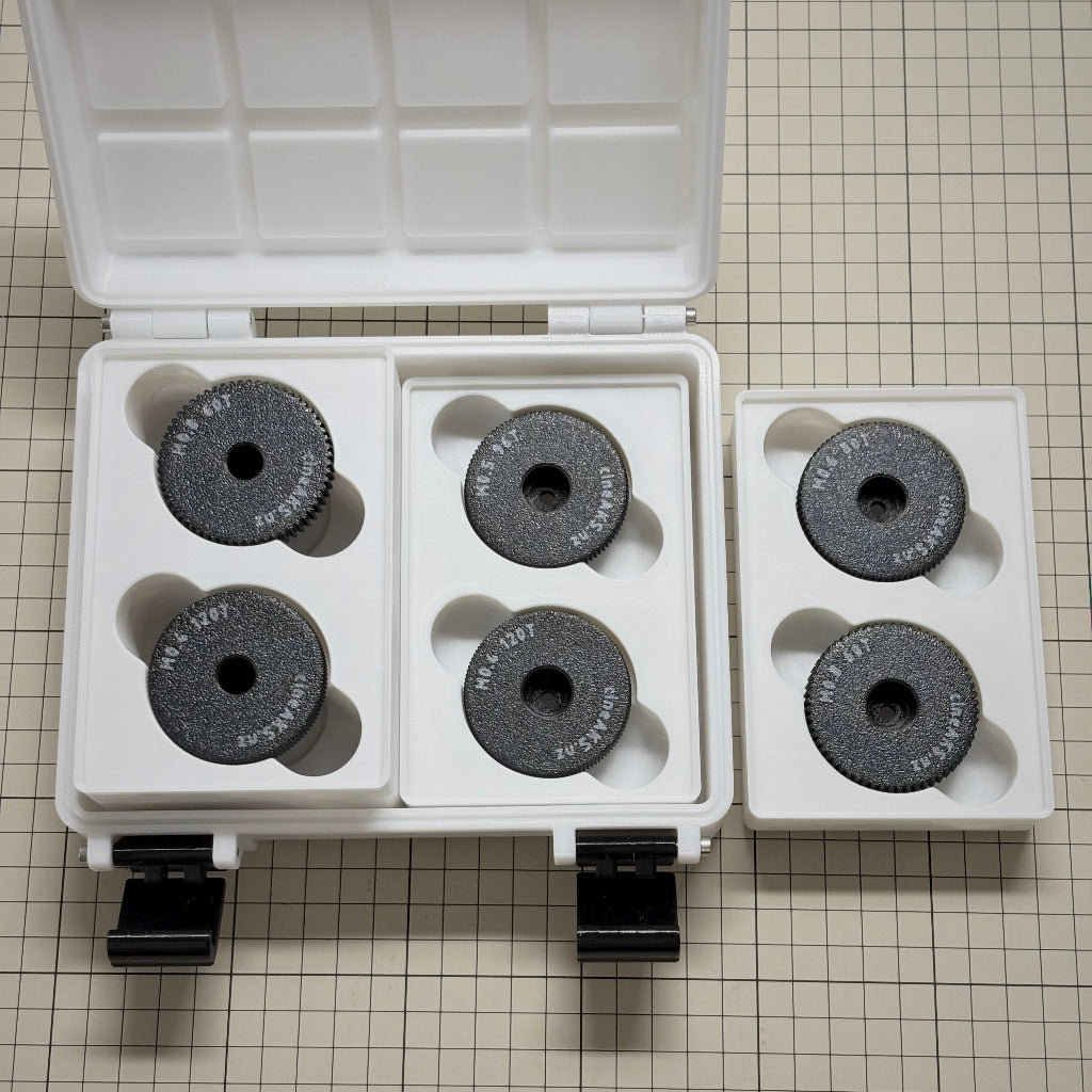 cineAKS cforce Offset Kit with 6 direct-fit offset and extra-offset lens gears in a white storgae case, with modular storage compartments. On a beige grid background.