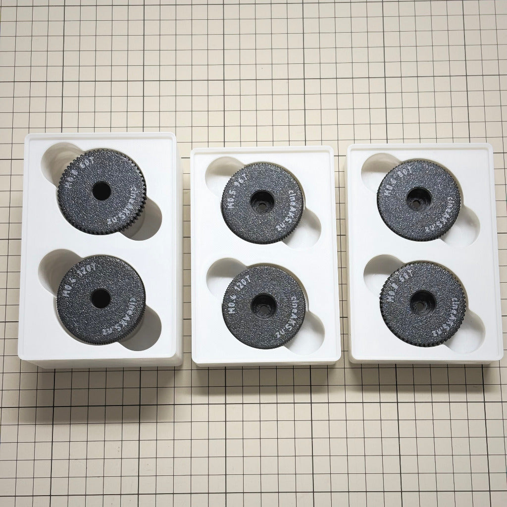 cineAKS cforce Offset Kit with 6 direct-fit offset and extra-offset lens gears in white gridfinity bins, photographed on a beige cutting mat.