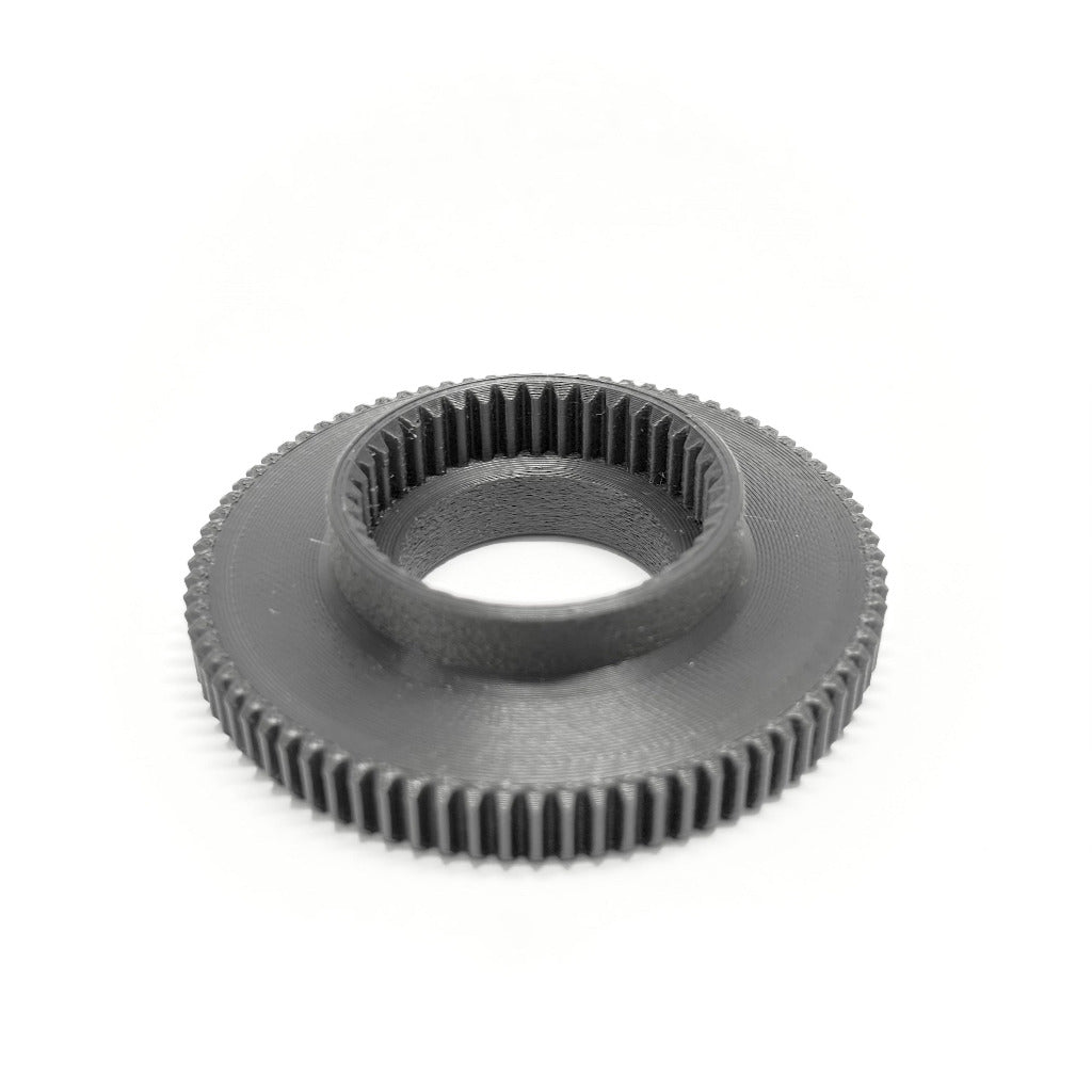 Back of a ARRI cforce Mini M0.8 push-on focus gear offset adapter by cineAKS, on a white background