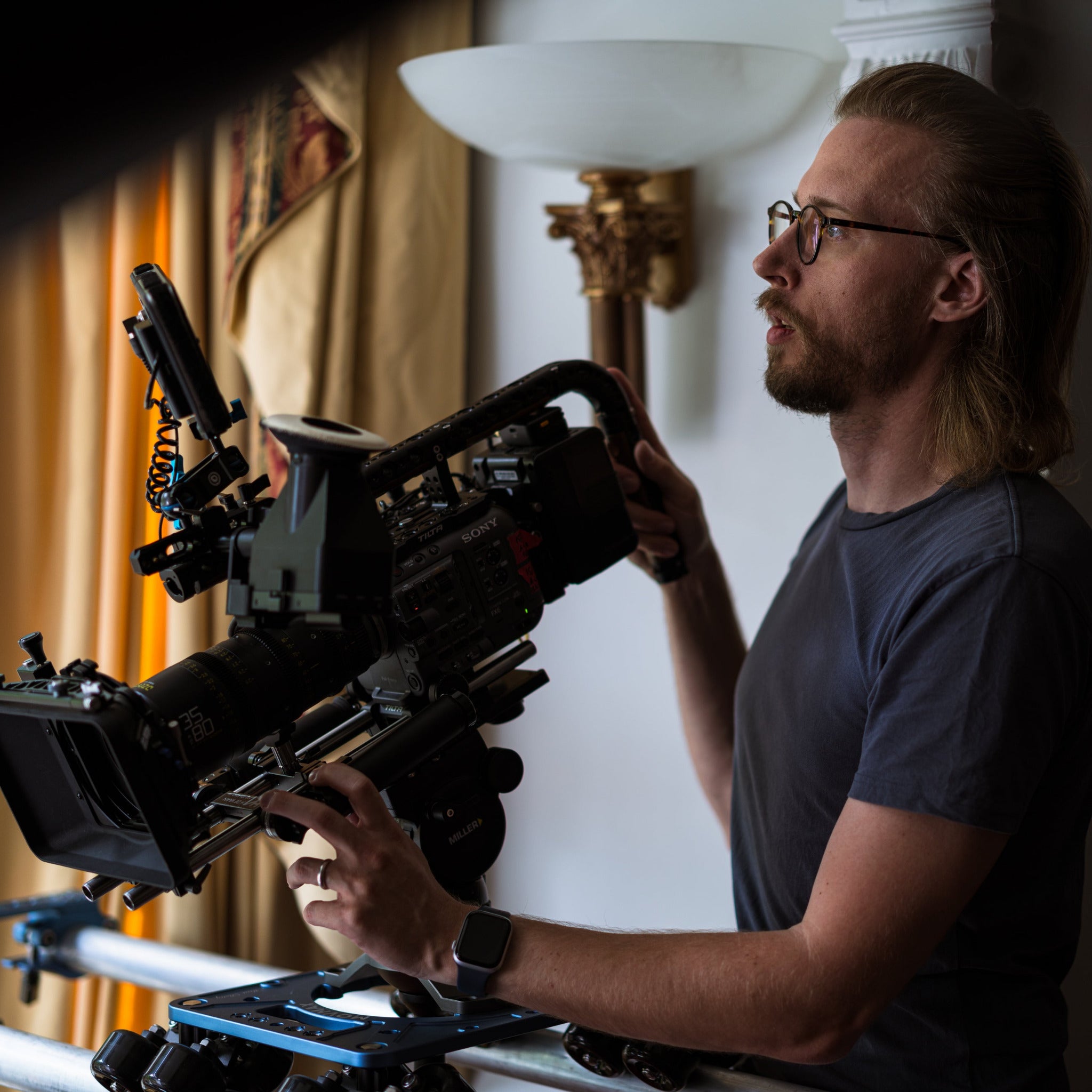 cinematographer operating a sony FX6 on a movcam dana dolly. Sony FX6 lcd viewfinder also visible