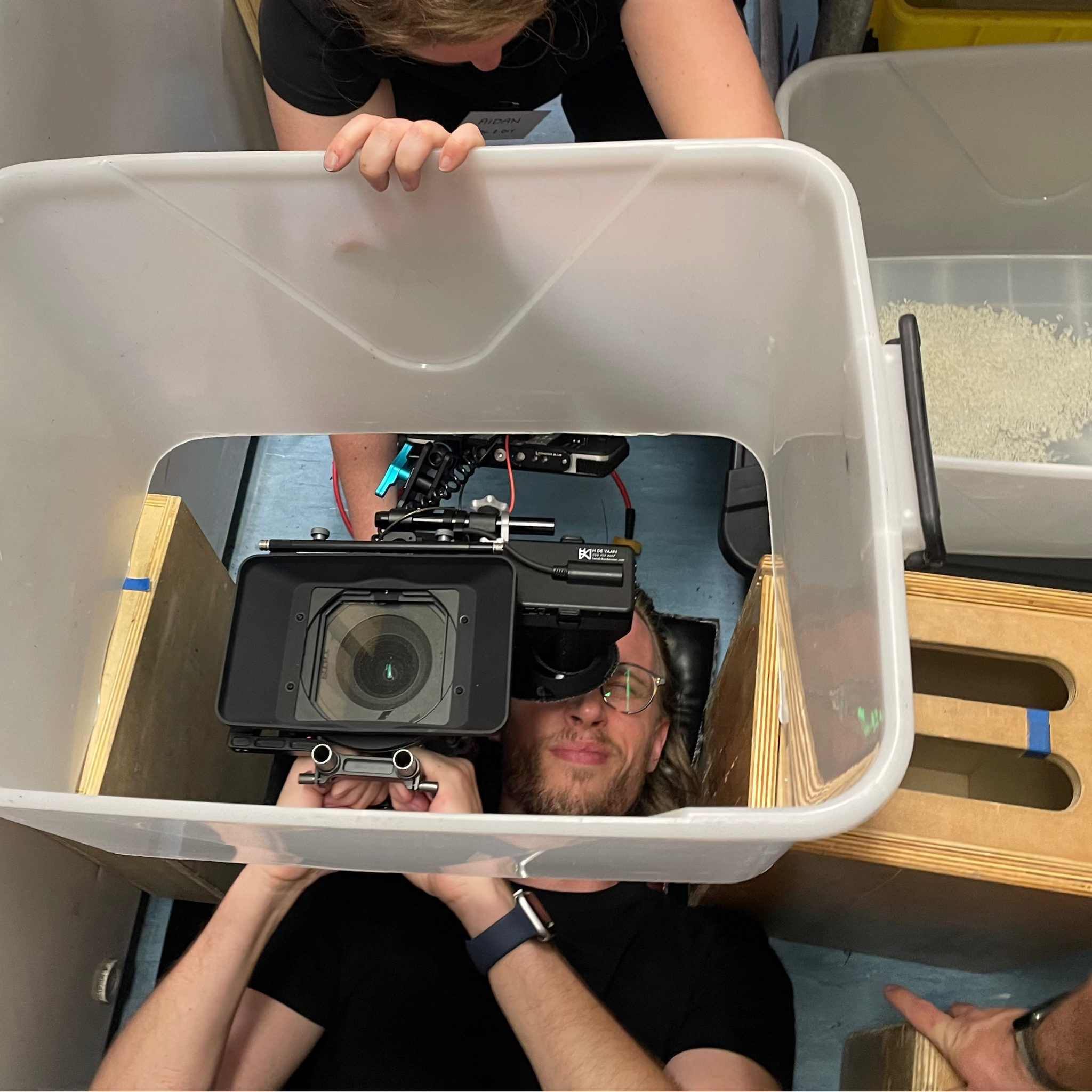 Camera operator laying on the ground using a FX6 with viewfinder eyepiece