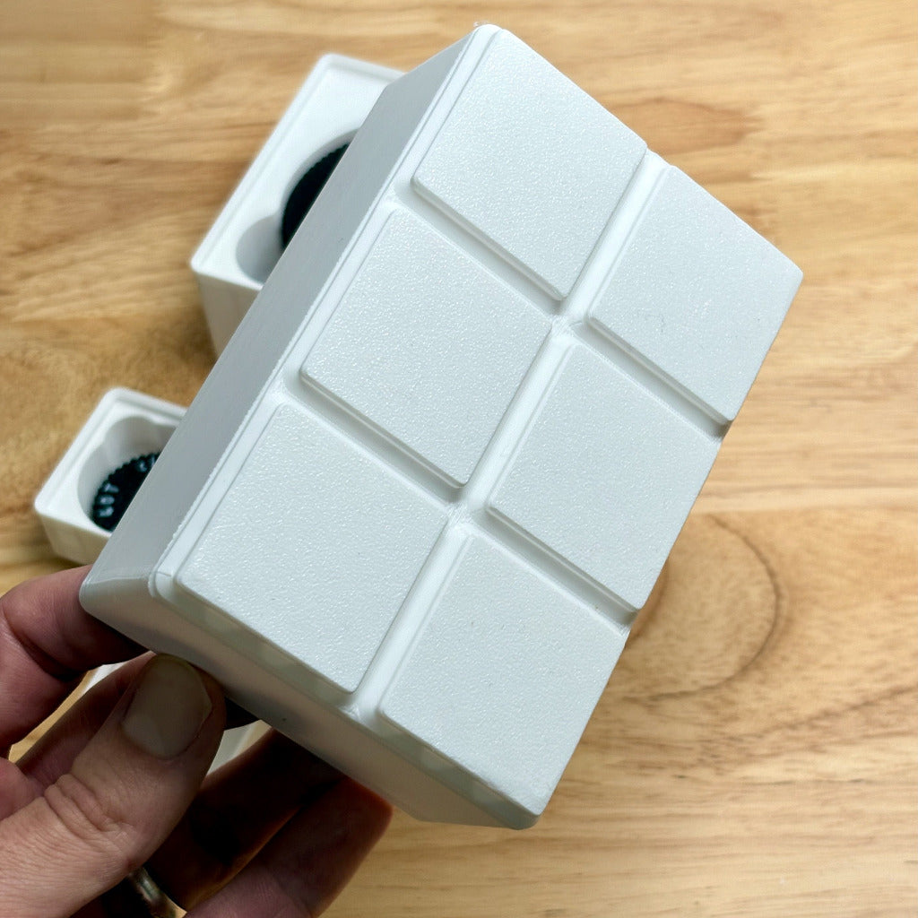 bottom of a white gridfinity bin on a wooden background