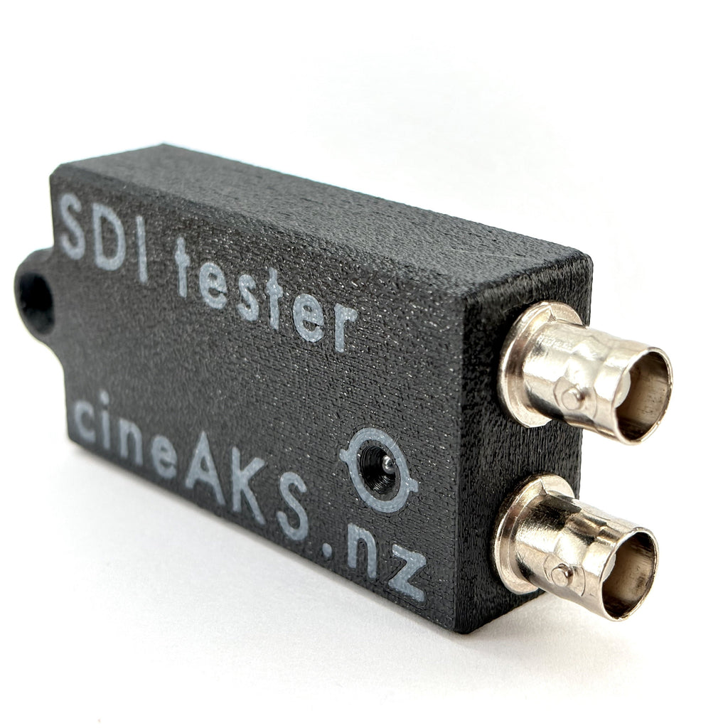 SDI tester with 'cineAKS.nz' branding on a white background