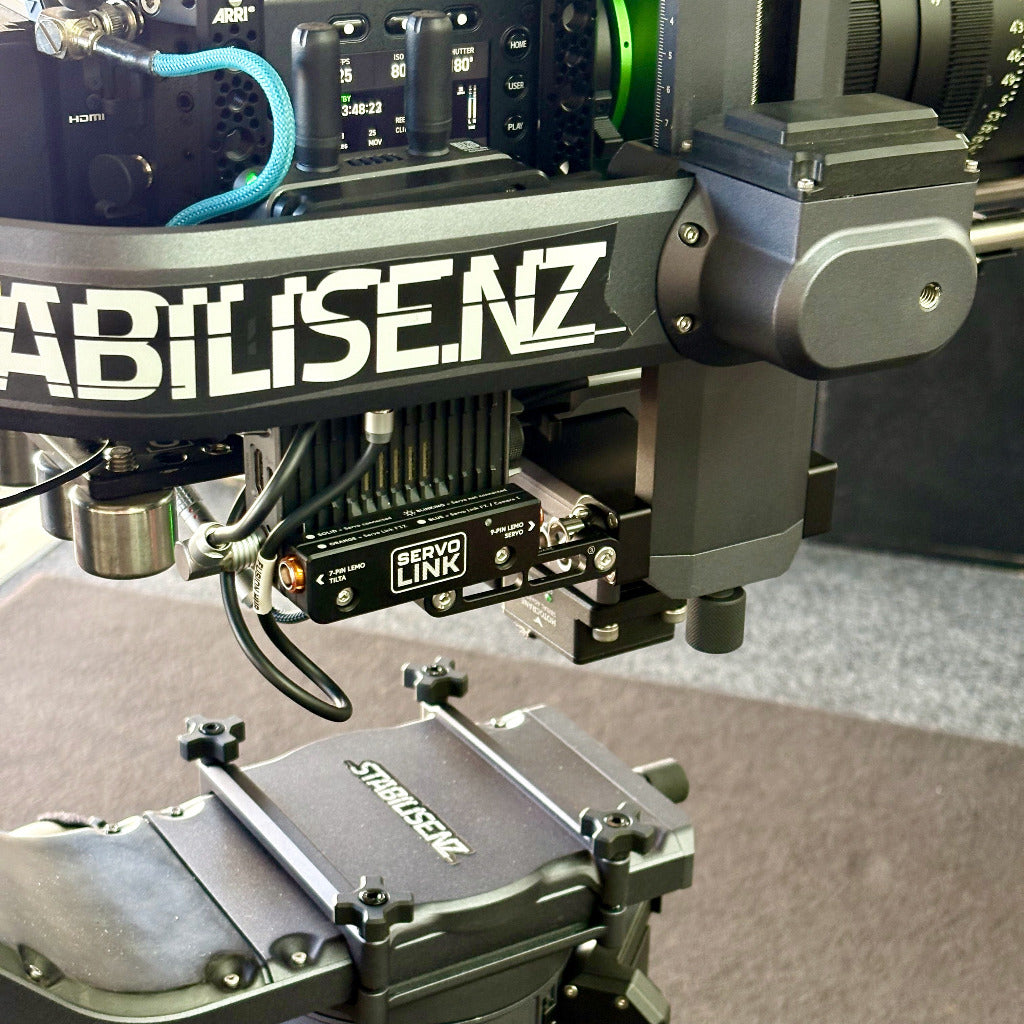 Close-up of a camera rig with visible branding including STABILISENZ and SERVOLINK on metal mounting hardware bycineAKS.nz for Motocrane Titan LT